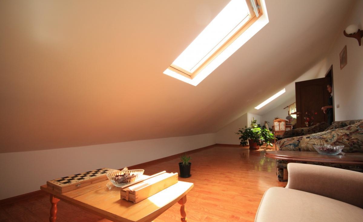 Salon de relaxare la mansardă, cu lumină naturală și joc de șah